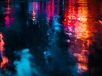 neon lights reflected in puddles after rain